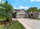 Charming home featuring a two-car garage, manicured lawn, and lush landscaping at 8304 Shooting Star Rd, Sarasota, FL 34241
