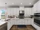 Modern kitchen with white cabinets, stainless steel appliances, a stylish backsplash, and ample storage space for cooking at 8304 Shooting Star Rd, Sarasota, FL 34241