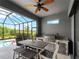 Outdoor screened-in patio with outdoor kitchen, stainless steel appliances, table, and view of the pool at 8304 Shooting Star Rd, Sarasota, FL 34241