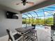 Screened-in patio features a ceiling fan, TV, and overlooks a lovely swimming pool at 8304 Shooting Star Rd, Sarasota, FL 34241