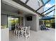 The covered lanai has a ceiling fan, TV, and dining table, perfect for relaxing outside at 8304 Shooting Star Rd, Sarasota, FL 34241