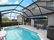 Screened-in pool area is enhanced by the patio dining area, umbrella, and landscaping at 8304 Shooting Star Rd, Sarasota, FL 34241