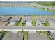 Aerial view of gray houses on a street near a shimmering blue lake in a well maintained neighborhood at 8529 Saint Kitts Cir, Englewood, FL 34224