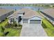 Aerial view of beautiful single-story home showcasing landscaping, paved driveway, and serene lake views at 8529 Saint Kitts Cir, Englewood, FL 34224