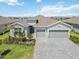 Aerial view of the home showing the three car garage, landscaping, and paver driveway at 8529 Saint Kitts Cir, Englewood, FL 34224