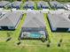 Aerial view of a screened-in backyard pool with a dining table and manicured lawn at 8529 Saint Kitts Cir, Englewood, FL 34224
