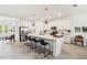 Bright, modern kitchen with stainless steel appliances, center island with seating, and open to living area at 8529 Saint Kitts Cir, Englewood, FL 34224