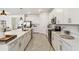 Contemporary kitchen with quartz countertops, white cabinets, and stainless steel appliances at 8529 Saint Kitts Cir, Englewood, FL 34224