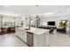 Open concept kitchen with large island and view to dining and living areas in modern new construction home at 8529 Saint Kitts Cir, Englewood, FL 34224