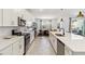 Bright kitchen with modern stainless steel appliances, a large island, and a view into the dining area at 8529 Saint Kitts Cir, Englewood, FL 34224