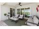 Relaxing lanai with ceiling fan, neutral furnishings, and sliding glass doors overlooking the water at 8529 Saint Kitts Cir, Englewood, FL 34224