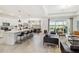 Open-concept living area with kitchen, island seating, and lake views from expansive sliding glass doors at 8529 Saint Kitts Cir, Englewood, FL 34224