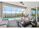 A covered patio features comfortable seating and a lovely view of the pool and lake at 8529 Saint Kitts Cir, Englewood, FL 34224