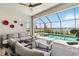 Covered outdoor pool with seating area, fan and serene lake view at 8529 Saint Kitts Cir, Englewood, FL 34224