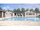 Community pool with a modern white pool house and ample lounge chairs for resident relaxation at 8529 Saint Kitts Cir, Englewood, FL 34224