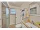 Bathroom featuring a shower with glass doors, tiled walls, and cabinet storage at 8701 Pickwick Rd, North Port, FL 34287