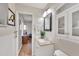 Bright bathroom with a mirrored vanity, cabinet storage, and tiled walls at 8701 Pickwick Rd, North Port, FL 34287