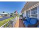 Cozy front porch with comfortable blue couch, wicker chair, and view of a quiet street at 8701 Pickwick Rd, North Port, FL 34287