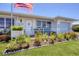 Inviting front porch featuring comfortable seating, beautiful plants, and an American flag at 8701 Pickwick Rd, North Port, FL 34287