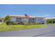 Single-story home featuring an American flag, manicured lawn, and beautiful landscaping at 8701 Pickwick Rd, North Port, FL 34287