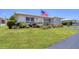 Attractive single-story home with a beautiful green lawn, American flag, and charming landscape at 8701 Pickwick Rd, North Port, FL 34287