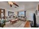 Cozy living room with neutral sofas, a ceiling fan, and a view of the front yard at 8701 Pickwick Rd, North Port, FL 34287