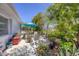 Serene patio area with comfortable seating, a small table, and a garden area with flowers, perfect for enjoying the outdoors at 8701 Pickwick Rd, North Port, FL 34287