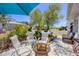 Relaxing patio area featuring outdoor seating, a glass-topped table, a shade umbrella, and lush landscaping for comfortable outdoor living at 8701 Pickwick Rd, North Port, FL 34287