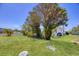 Well-maintained yard with lush green grass and mature trees, offering a peaceful and inviting outdoor space with shade at 8701 Pickwick Rd, North Port, FL 34287