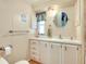 Traditional bathroom with cabinets, mirror, and decorative wall art at 881 Grado Dr, Venice, FL 34285