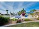 Welcoming Venice Isle Oasis community sign framed by lush landscaping with vibrant flowers and verdant palm trees at 881 Grado Dr, Venice, FL 34285