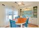 Bright dining area featuring a wooden table, blue chairs, and built-in shelving at 881 Grado Dr, Venice, FL 34285