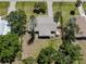 An aerial view of a single-Gathering home featuring a large yard with mature trees and a backyard patio at 929 Cypress Ave, Venice, FL 34285