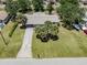 Aerial view of the property showcasing its well-maintained lawn, mature palm trees, and driveway at 929 Cypress Ave, Venice, FL 34285