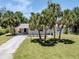 Inviting home with a carport and mature palm trees enhancing the curb appeal at 929 Cypress Ave, Venice, FL 34285