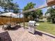 Cozy brick patio featuring a grill, dining table, chairs, and umbrella for outdoor enjoyment at 929 Cypress Ave, Venice, FL 34285