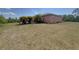 View of the property's backyard with sparse grass and lush shrubbery at 98 Maltby St, Port Charlotte, FL 33953
