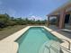 Backyard pool surrounded by lush landscaping with the home's exterior in the background at 98 Maltby St, Port Charlotte, FL 33953