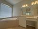 Bright bathroom featuring a tub, vanity, and tiled floor at 98 Maltby St, Port Charlotte, FL 33953