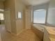 Bright bathroom with a large soaking tub under a window and tiled floors at 98 Maltby St, Port Charlotte, FL 33953