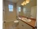 Well-lit bathroom featuring a tub with a window and a vanity with a sink and large mirror at 98 Maltby St, Port Charlotte, FL 33953