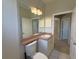 Bathroom with a large mirror over a vanity and sink, and a view of the doorway to the hallway at 98 Maltby St, Port Charlotte, FL 33953