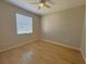 Neutral bedroom with hardwood floors, a ceiling fan, and a window with blinds to provide light at 98 Maltby St, Port Charlotte, FL 33953
