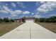 Charming single-story home featuring a long driveway, two-car garage, and a well-maintained front yard at 98 Maltby St, Port Charlotte, FL 33953