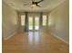 Large living room with new flooring, ceiling fan, and sliding door to outdoor view at 98 Maltby St, Port Charlotte, FL 33953