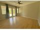 Spacious living room with new floors, ceiling fan, and sliding doors to outside at 98 Maltby St, Port Charlotte, FL 33953