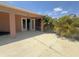 Backyard patio with covered area, lush landscaping, and a view inside at 98 Maltby St, Port Charlotte, FL 33953