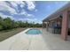 Outdoor pool surrounded by concrete patio with hot tub and view of trees at 98 Maltby St, Port Charlotte, FL 33953