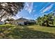 Spacious backyard with lush landscaping, tile roof, and screened in patio at 1037 Beckley Cir, Venice, FL 34292