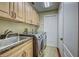 Laundry room with stainless steel washer and dryer, granite countertops, and wood cabinets at 1037 Beckley Cir, Venice, FL 34292